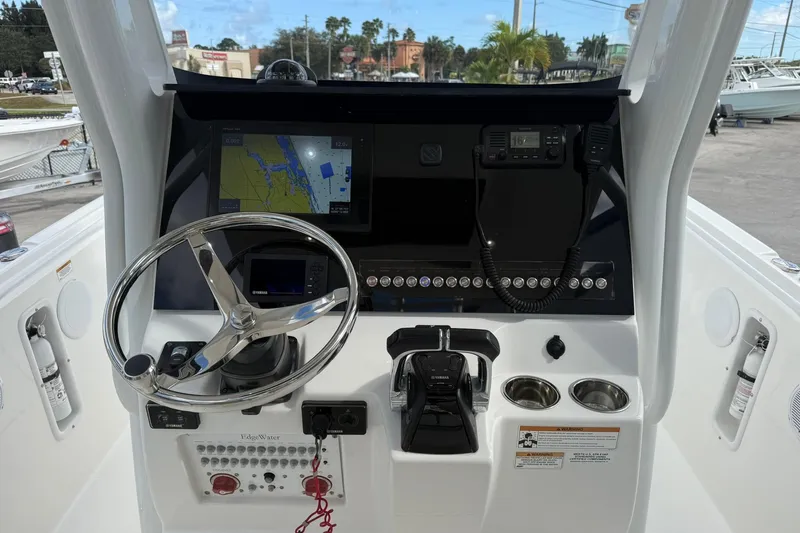 Slide: The Image of 2018 Edgewater 262CC boat dashboard with steering wheel, navigation display, and controls. - 20