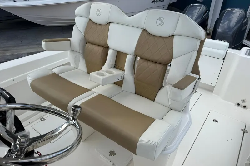 Slide: The Image of Luxurious seating on 2018 Edgewater 262CC boat, featuring tan and white upholstery. - 21