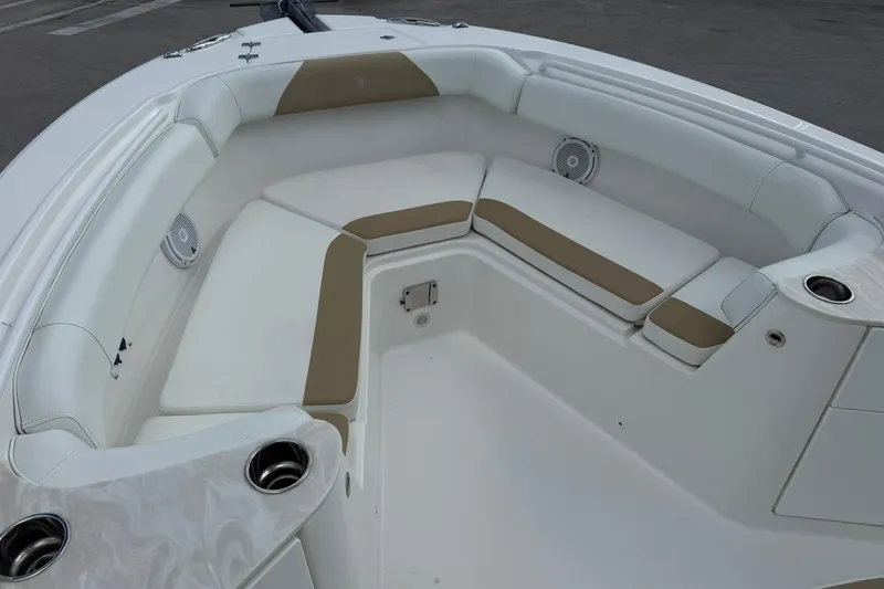 Slide: The Image of 2018 Edgewater 262CC boat interior with cushioned seating and cup holders. - 28