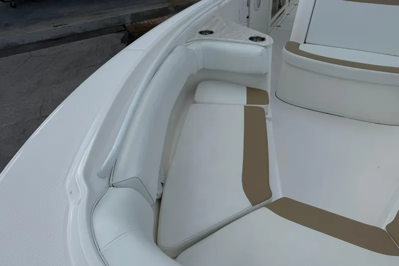 Slide: The Image of 2018 Edgewater 262CC boat interior with cushioned seating and cup holders. - 31