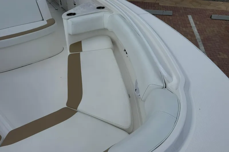 Slide: The Image of 2018 Edgewater 262CC boat interior with white and tan cushioned seating. - 32