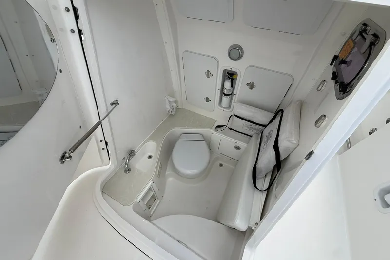 Slide: The Image of 2018 Edgewater 262CC boat interior with compact bathroom and storage compartments. - 34
