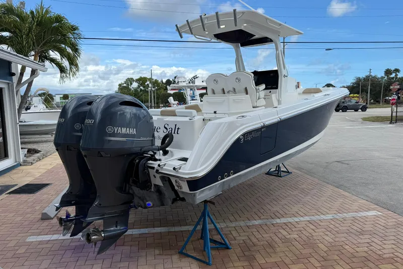 Slide: The Image of 2018 Edgewater 262CC boat with dual Yamaha engines on display outdoors. - 4