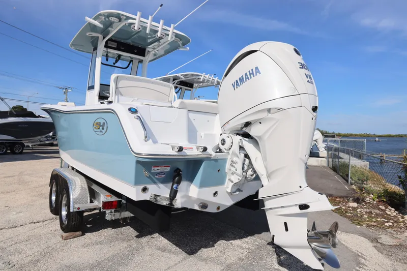Slide: The Image of 2026 Sea Hunt Ultra 245 SE boat with Yamaha engine, parked near waterfront. - 10