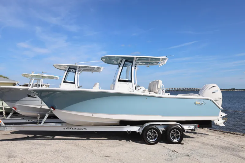 Slide: The Image of 2026 Sea Hunt Ultra 245 SE boat on trailer by the water. - 20