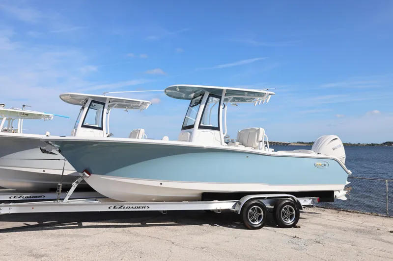 Slide: The Image of 2026 Sea Hunt Ultra 245 SE boat on trailer by waterfront. - 21