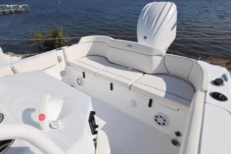 Slide: The Image of 2026 Sea Hunt Ultra 245 SE boat interior with seating and Yamaha engine by the water. - 6