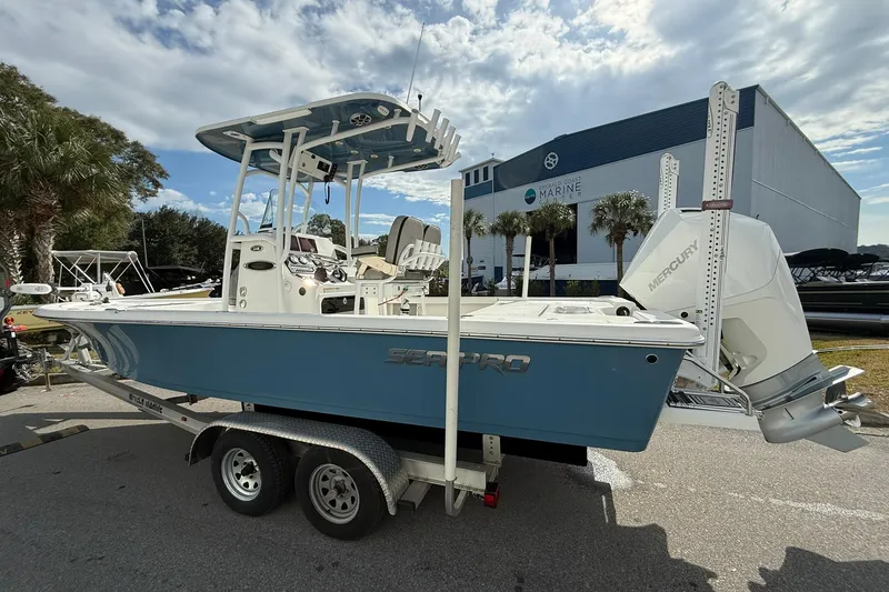 Slide: The Image of 2021 Sea Pro 248 Bay boat with Mercury engine on trailer, parked near marine facility. - 1