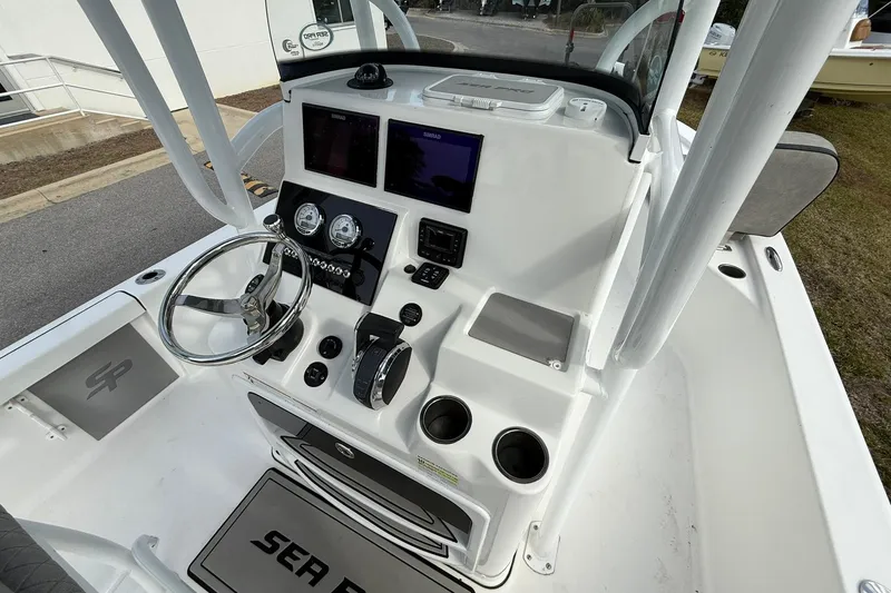 Slide: The Image of 2021 Sea Pro 248 Bay boat console with steering wheel, gauges, and controls. - 18