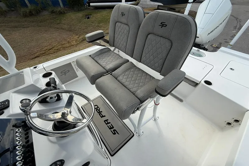 Slide: The Image of 2021 Sea Pro 248 Bay boat helm with dual seats and steering wheel. - 21