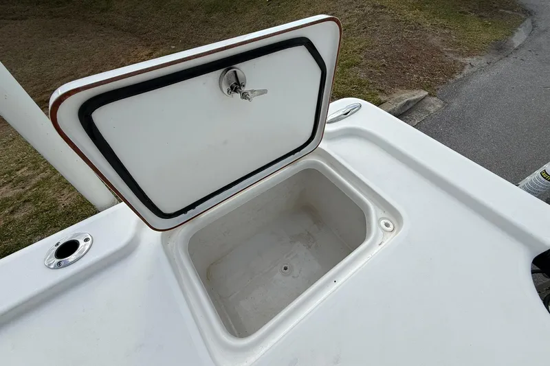 Slide: The Image of Open storage compartment on 2021 Sea Pro 248 Bay boat, featuring secure latch. - 26