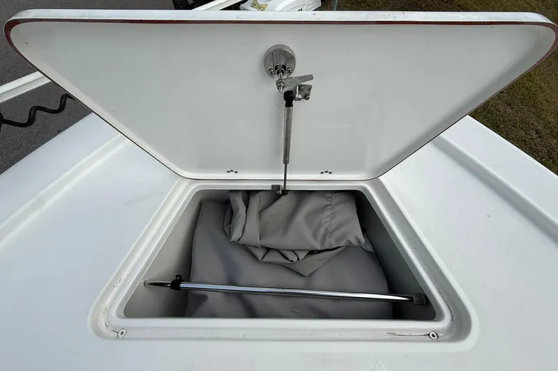 Slide: The Image of Open storage compartment on 2021 Sea Pro 248 Bay boat, containing a folded cover. - 9