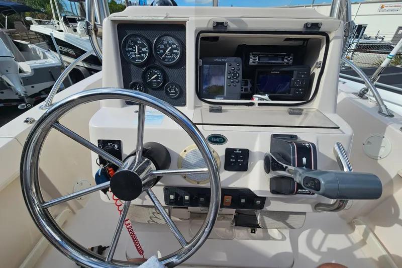Slide: The Image of 2001 Grady-White Sportsman 180 boat dashboard with steering wheel and navigation instruments. - 21