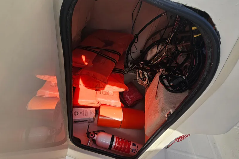 Slide: The Image of Storage compartment of a 2001 Grady-White Sportsman 180 with life jackets and safety equipment. - 26