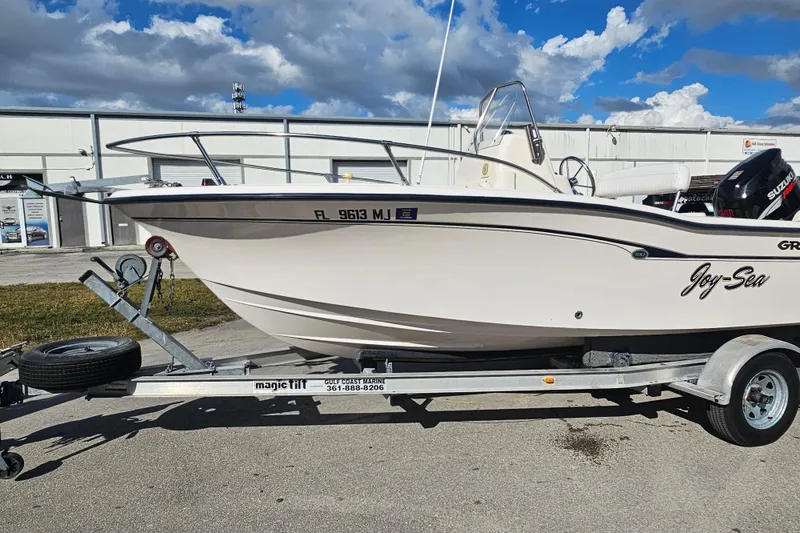 Slide: The Image of 2001 Grady-White Sportsman 180 boat on trailer, parked outdoors under a cloudy sky. - 6