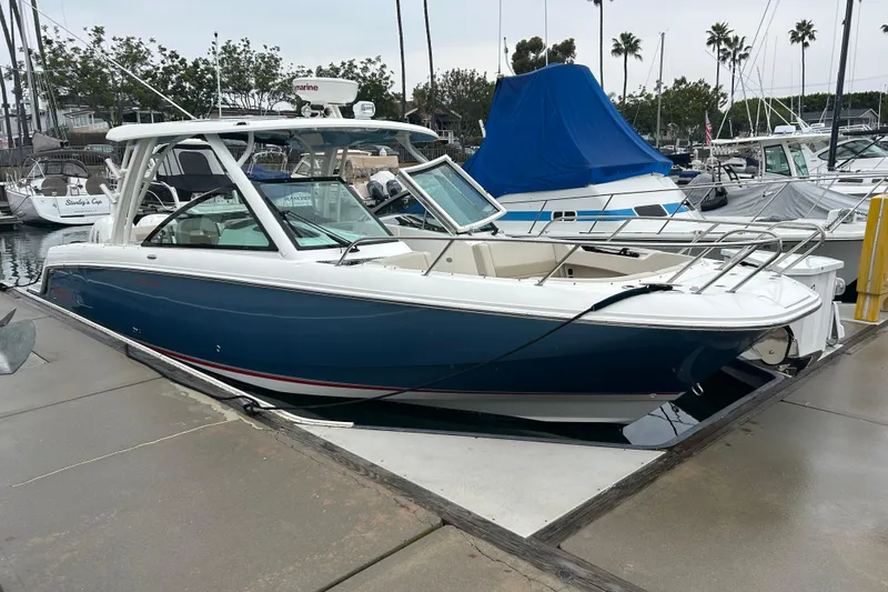 The Image of 2022 Boston Whaler 320 Vantage boat docked at marina, blue hull, sleek design. - 0