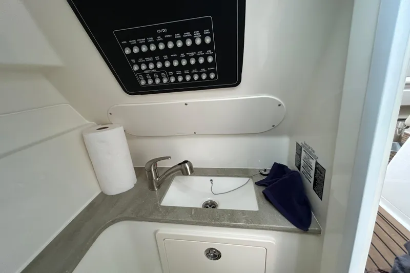 Slide: The Image of 2022 Boston Whaler 320 Vantage interior sink area with control panel and paper towel. - 11