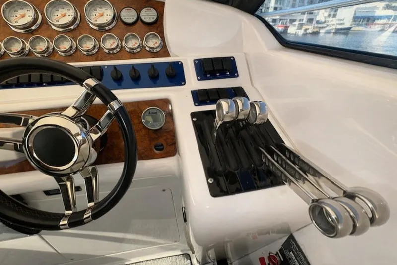 Slide: The Image of Control panel of a 1994 Sunseeker Apache 45 boat with steering wheel and throttle levers. - 10