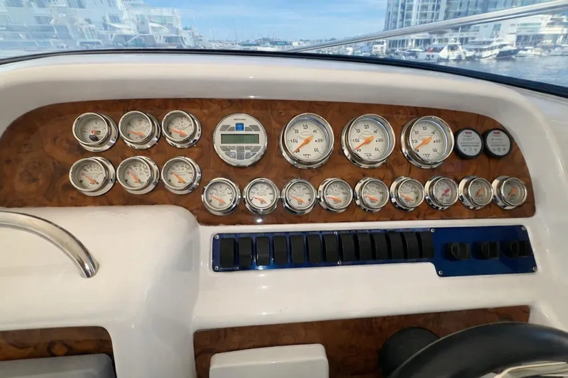 Slide: The Image of 1994 Sunseeker Apache 45 dashboard with gauges and controls, marina view in background. - 9