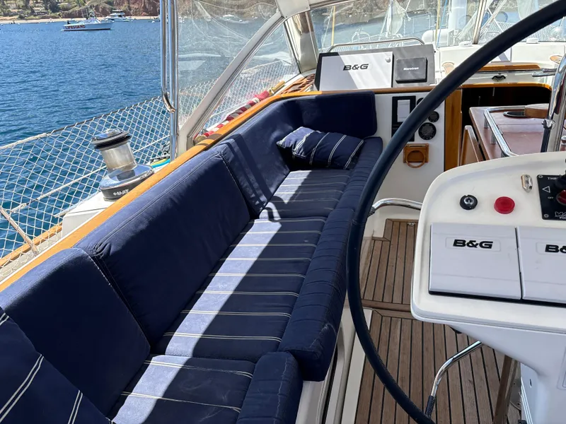Slide: The Image of Luxurious 2005 Beneteau 57 yacht cockpit with navy seating and B&G navigation system. - 12