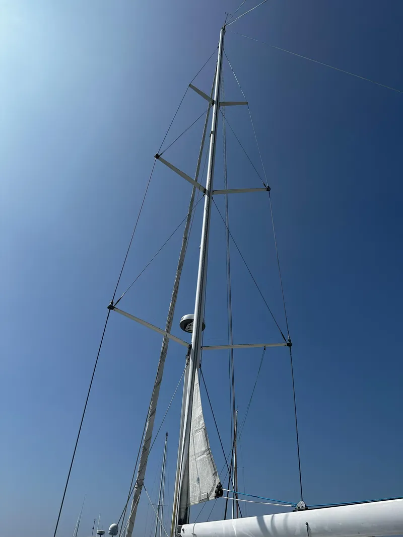 Slide: The Image of Tall mast of a 2005 Beneteau 57 sailboat against a clear blue sky. - 14