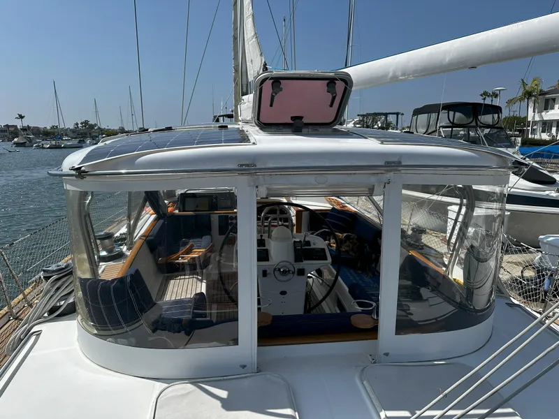 Slide: The Image of 2005 Beneteau 57 sailboat cockpit with clear enclosure, docked in a marina. - 15