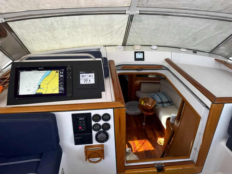 Slide: The Image of Beneteau 57 yacht interior, 2005 model, featuring navigation equipment and cozy cabin entrance. - 41