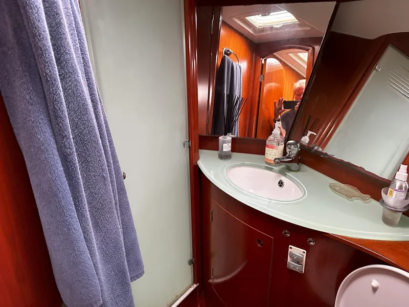 Slide: The Image of Luxurious bathroom in 2005 Beneteau 57 yacht with modern fixtures and wooden cabinetry. - 54