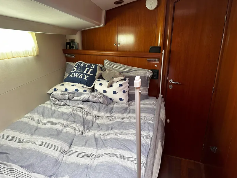 Slide: The Image of Cozy cabin interior of 2005 Beneteau 57 yacht with nautical-themed bedding. - 56