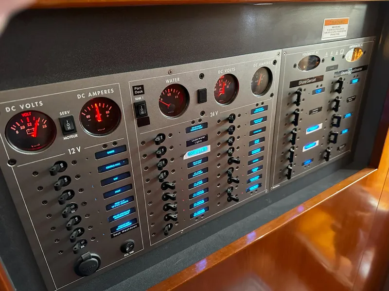 Slide: The Image of Electrical control panel on a 2005 Beneteau 57 yacht, featuring gauges and switches. - 59