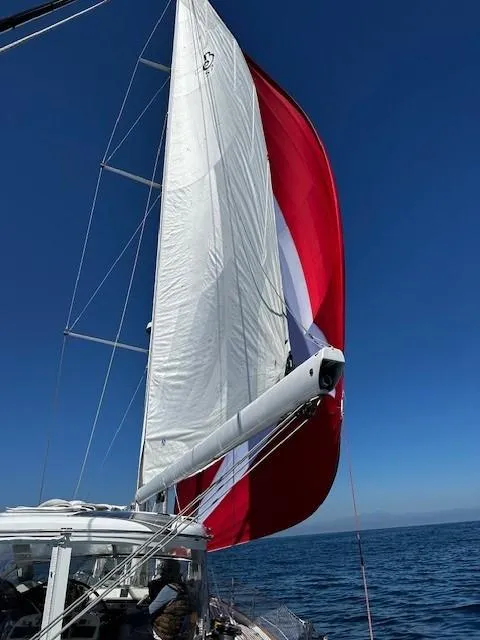 Slide: The Image of 2005 Beneteau 57 sailboat with red and white sails on open sea. - 62