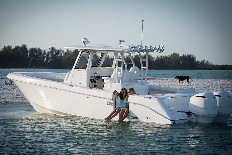 Slide: The Image of Manufacturer Provided Image: 2025 Everglades 335 Center Console boat on water with people and dog nearby. - 3