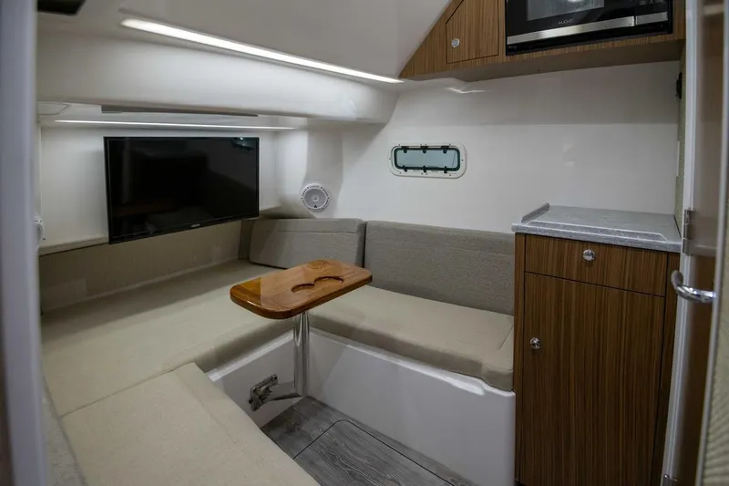 Slide: The Image of 2026 Everglades 395 Center Console cabin with TV, seating, and wood accents. - 11