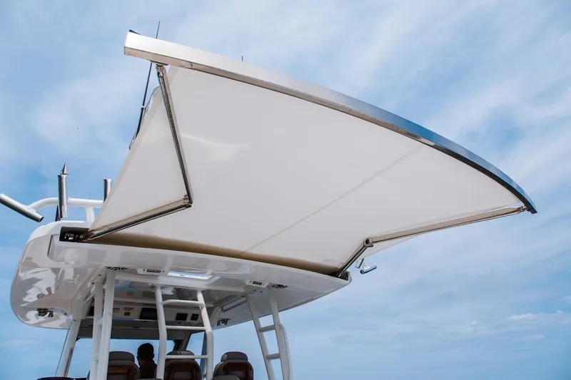 Slide: The Image of 2026 Everglades 395 Center Console boat with extended canopy under blue sky. - 13