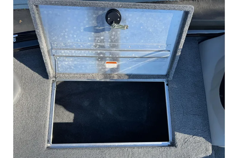 Slide: The Image of Open storage compartment on 2017 Tracker Pro Team 195 TXW boat, featuring a secure lock. - 10