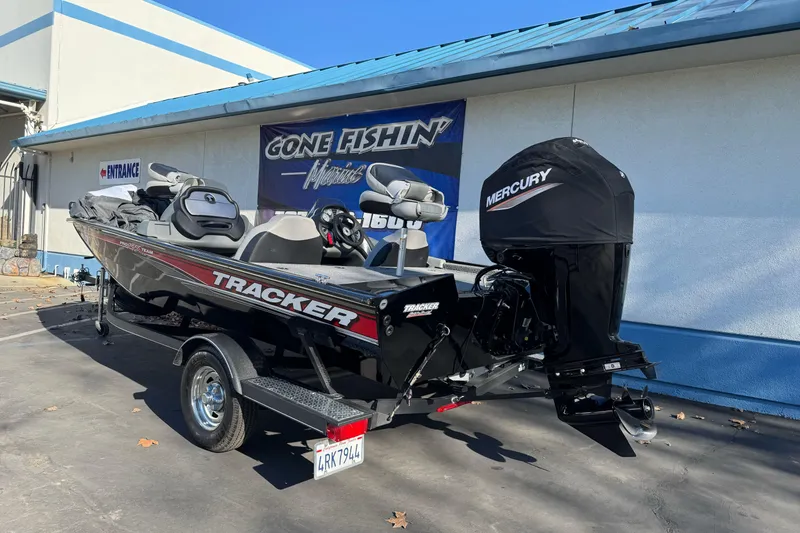 Slide: The Image of 2017 Tracker Pro Team 195 TXW boat with Mercury engine, parked outside a fishing store. - 5
