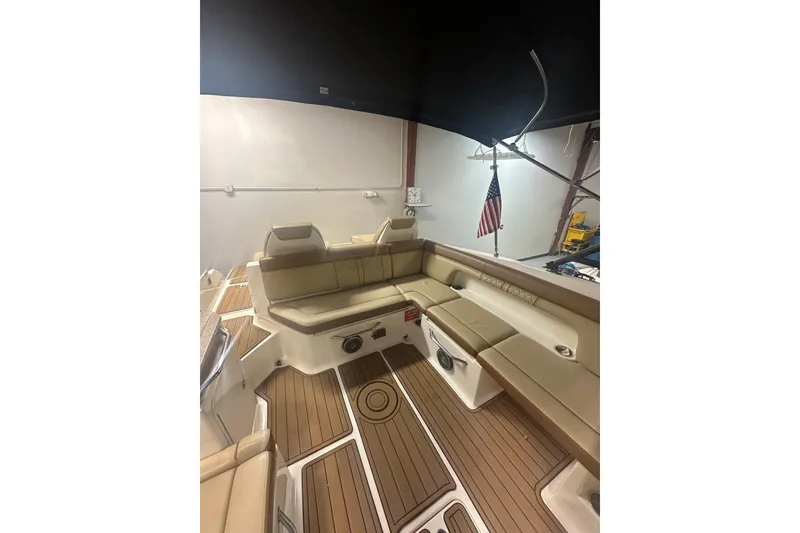 Slide: The Image of 2015 Sea Ray 290 Sundeck interior with tan seating and wood flooring. - 10