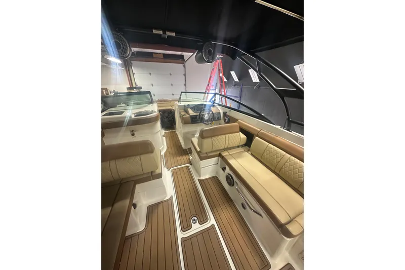 Slide: The Image of 2015 Sea Ray 290 Sundeck interior with tan seating and wood flooring. - 7