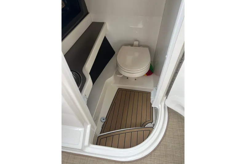 Slide: The Image of 2019 Sea Ray SLX 280 boat bathroom with toilet and wooden floor. - 12