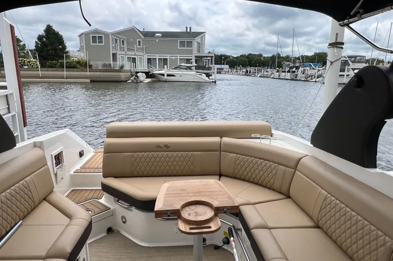 Slide: The Image of 2019 Sea Ray SLX 280 boat interior with tan seating, docked near waterfront homes. - 5