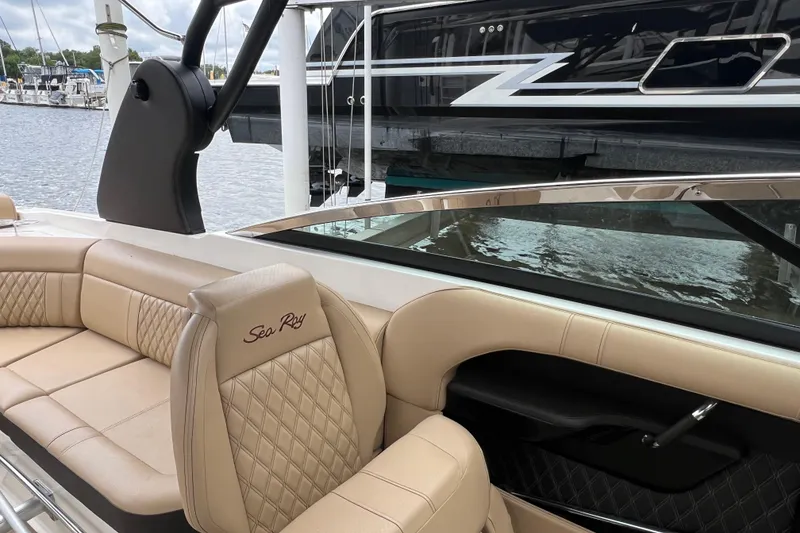 Slide: The Image of 2019 Sea Ray SLX 280 boat with luxurious beige seating at a marina. - 6