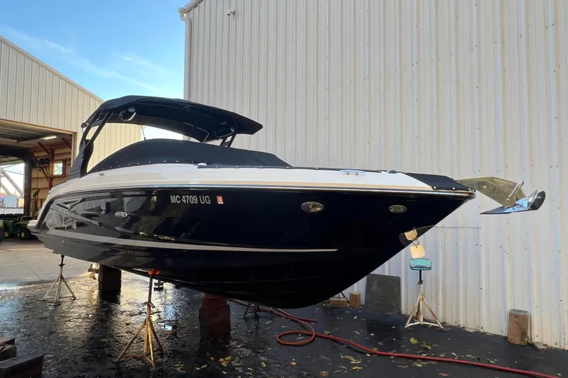 Slide: The Image of 2019 Sea Ray SLX 280 boat on stands near a warehouse. - 8