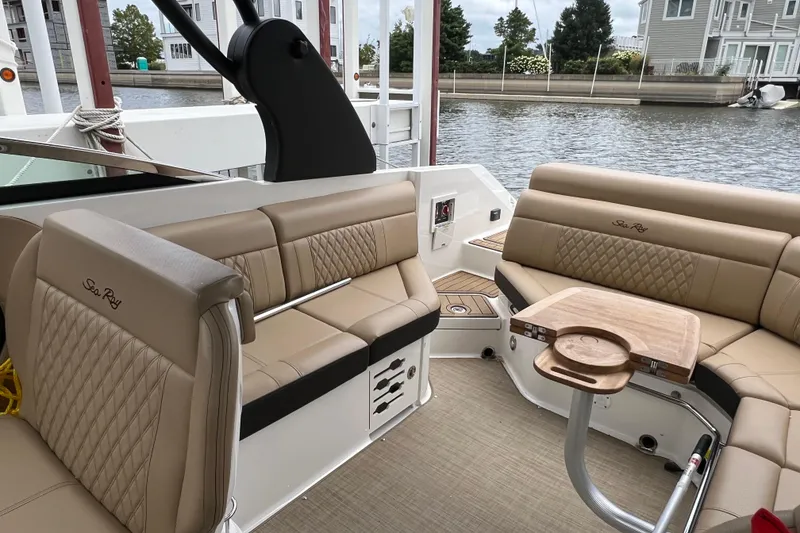 Slide: The Image of 2019 Sea Ray SLX 280 boat interior with beige seating and wooden table. - 9