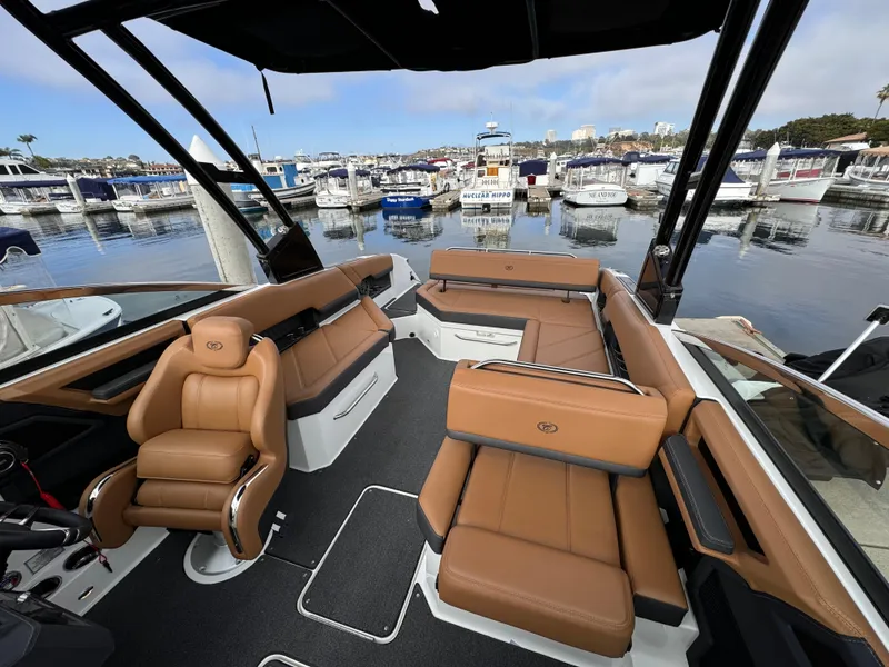 Slide: The Image of Luxurious 2022 Cobalt R8 boat interior with tan leather seating at a marina. - 13