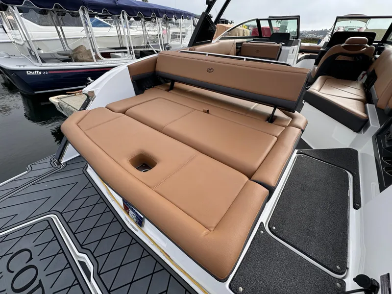 Slide: The Image of 2022 Cobalt R8 boat with tan leather seating, docked at marina. - 2