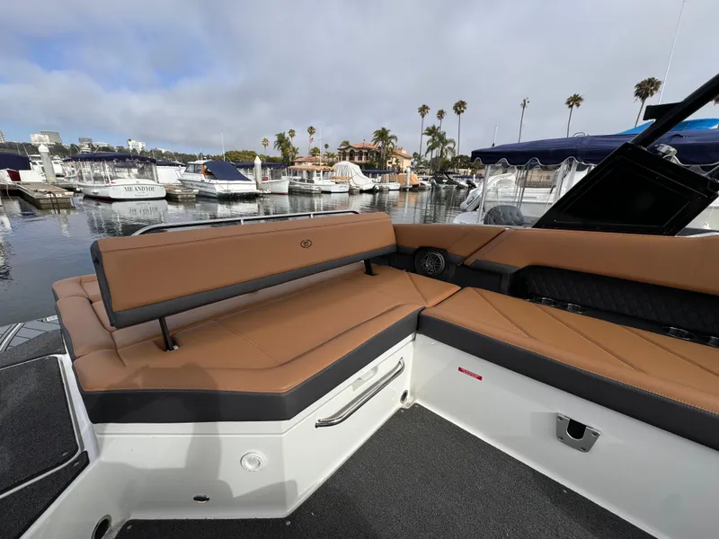 Slide: The Image of 2022 Cobalt R8 boat with tan seating at a marina, surrounded by yachts and palm trees. - 4
