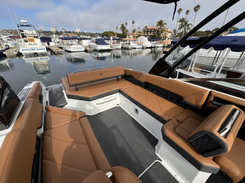 Slide: The Image of 2022 Cobalt R8 boat with tan seating, docked in a marina with other boats. - 7