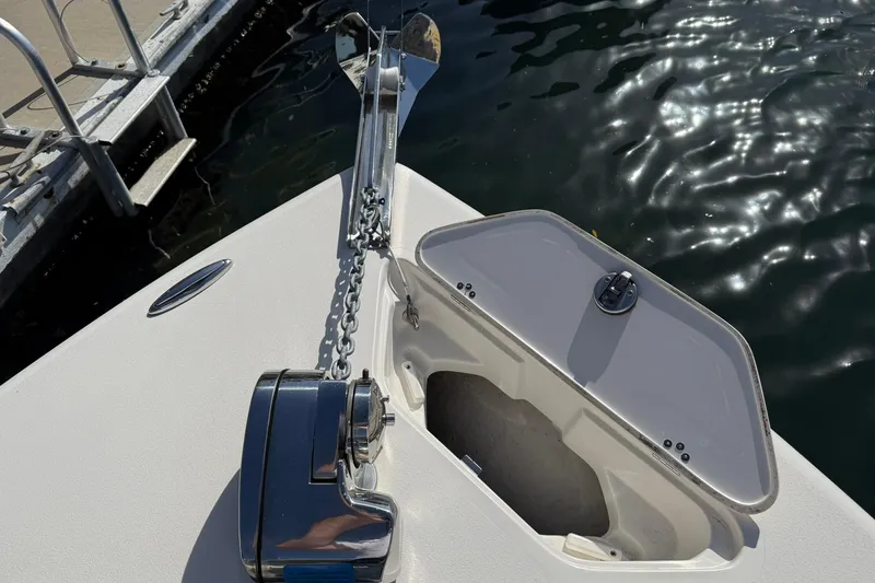 Slide: The Image of 2023 Key West 239 DFS boat anchor compartment with chain and winch by the dock. - 13