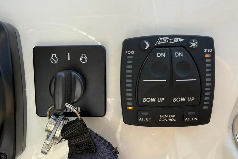 Slide: The Image of Control panel of 2023 Key West 239 DFS boat with ignition and trim tab controls. - 20