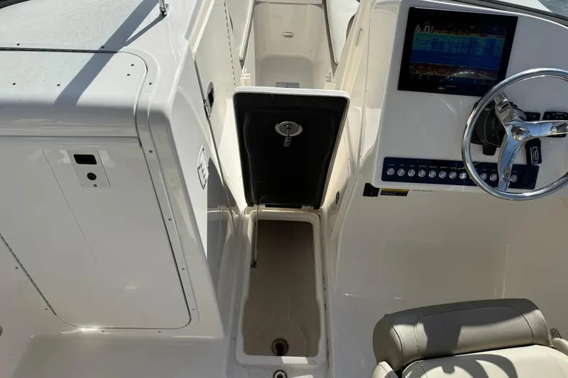 Slide: The Image of 2023 Key West 239 DFS boat interior with steering wheel and control panel. - 28